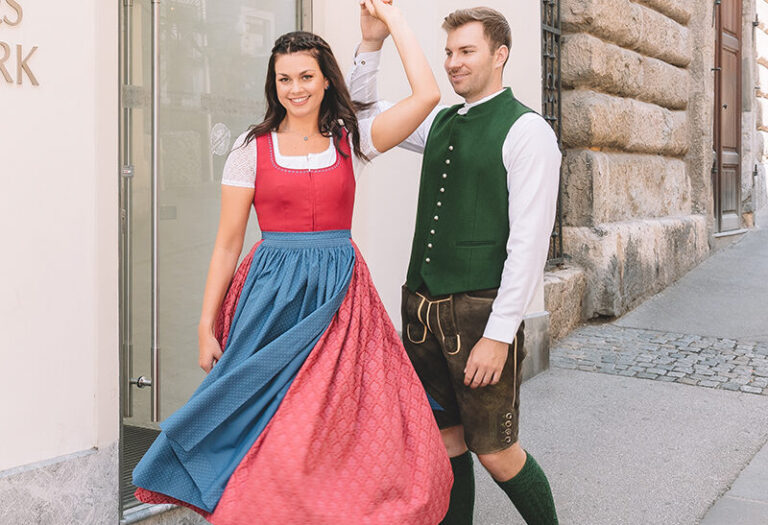 Tanzendes Paar in steirischer Tracht vor dem Steirischen Heimatwerk